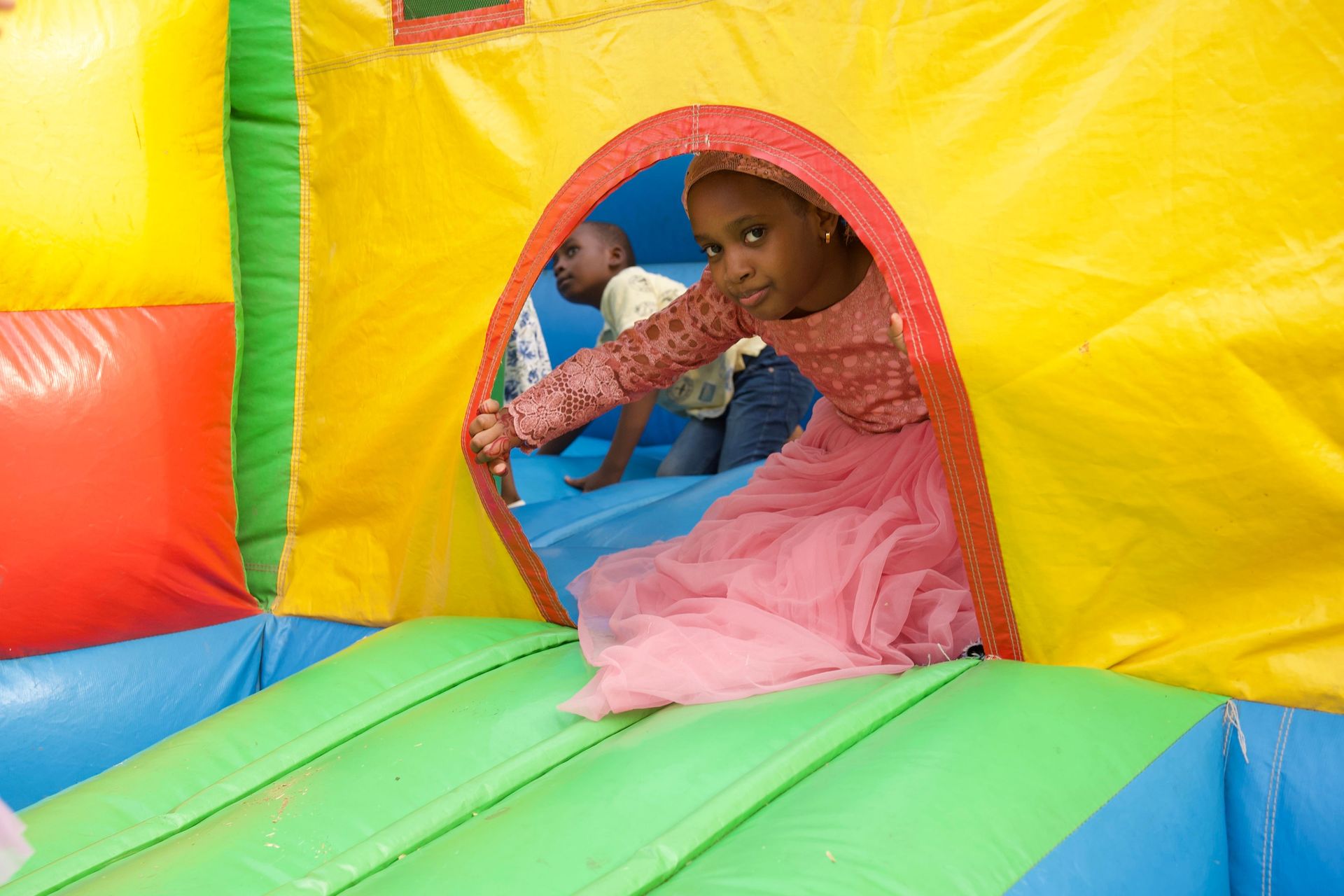 A child enjoying a birthday celebration in a colorful bouncy castle in Abuja, Nigeria.